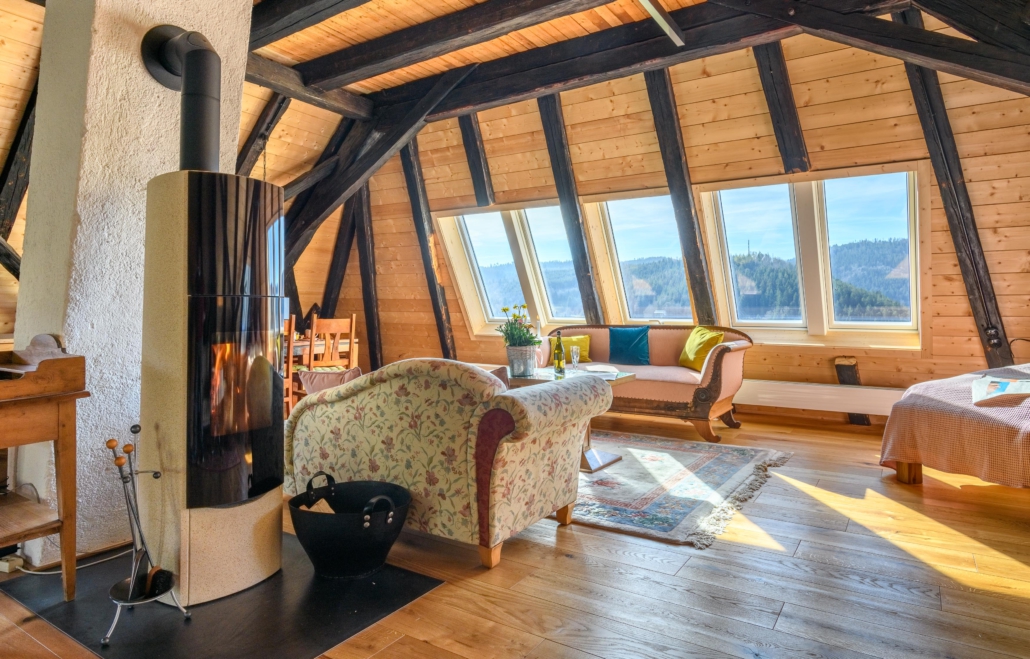 Wohnzimmer mit Kaminofen und 5 großen Panoramadachfenstern