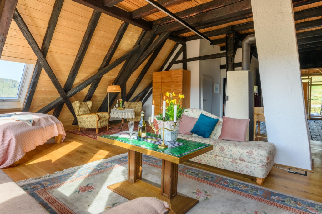 Couchtisch mit Sofa, im Hintergrund Bett und Leseecke