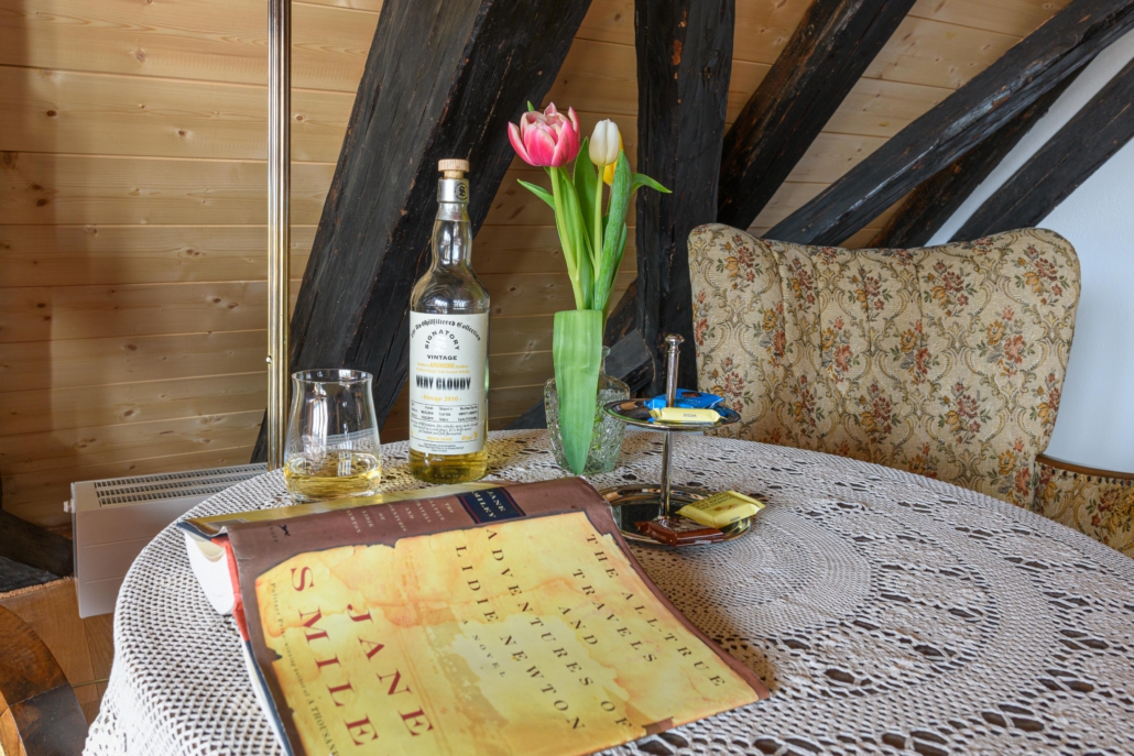 Tisch mit Buch und Getränk vor dem Sessel in der Leseecke