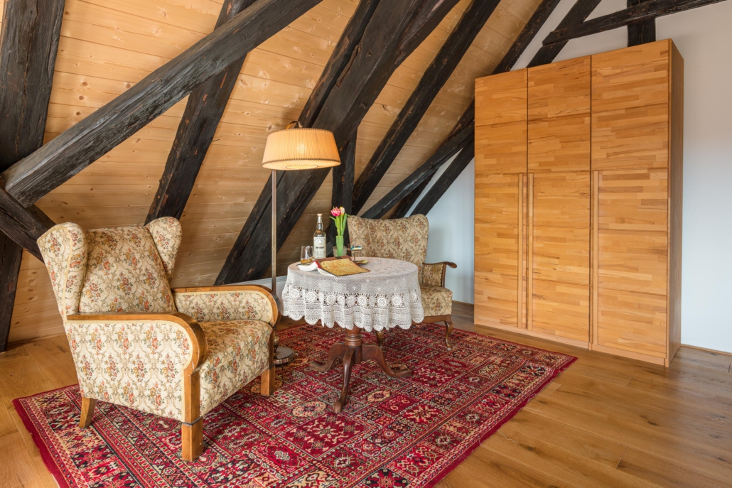 Leseecke mit Sesseln, Tisch und Stehlampe neben dreitürigem Kleiderschrank