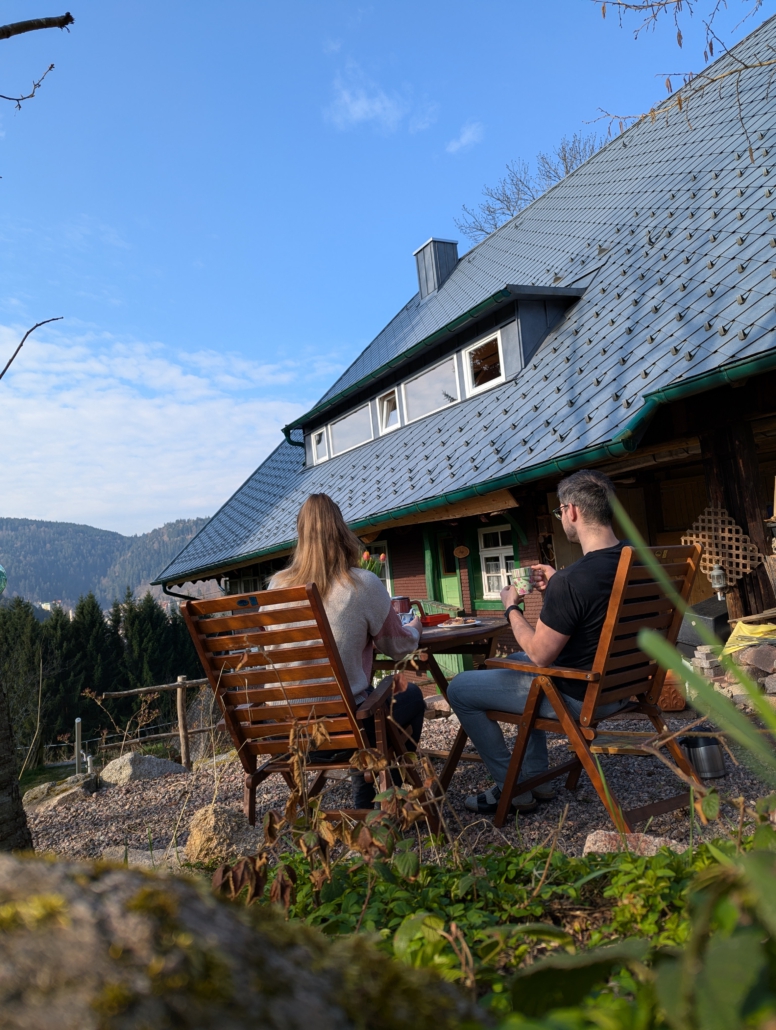 Mitten im Grünen sitzen und essen Terrasse mit Tisch und Stühlen neben dem Haus