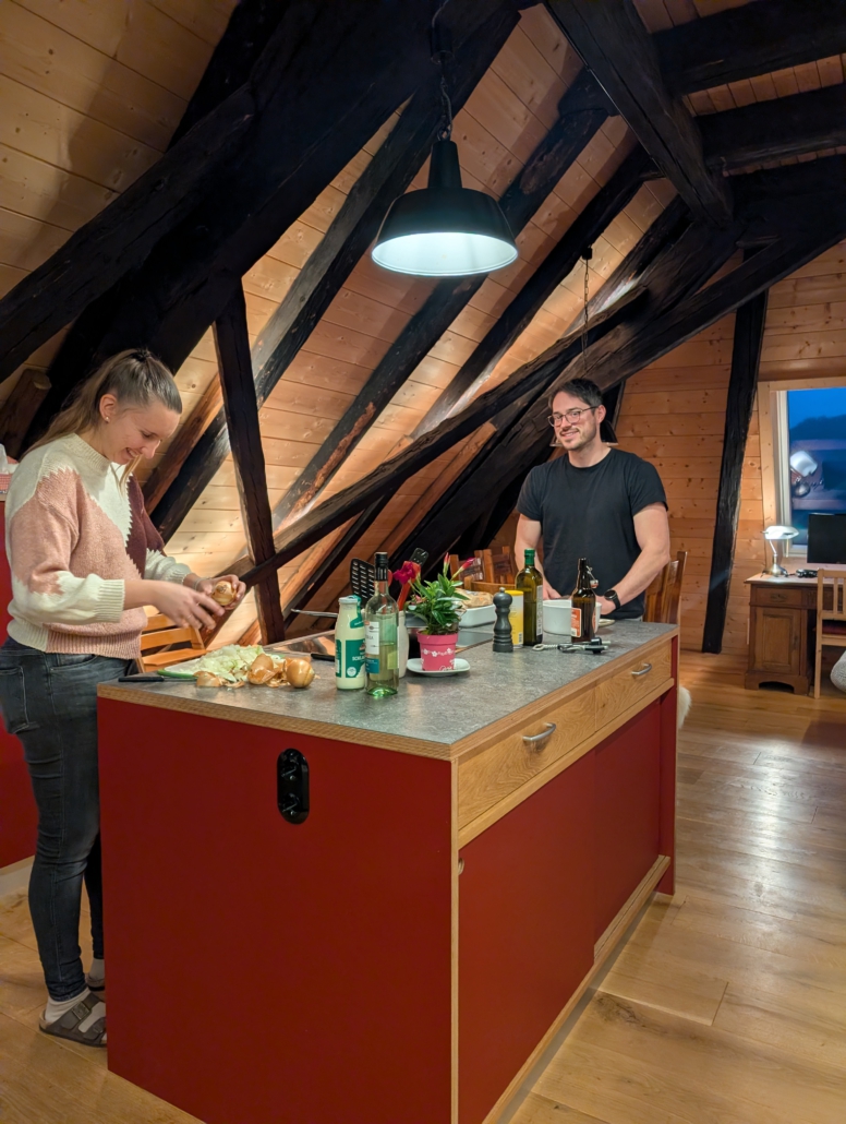 Gäste beim Kochen an der Kochinsel