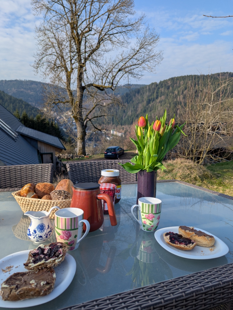 gedeckter Frühstückstisch auf der Terrasse mit Aussicht